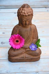 Foto auf Acrylglas Buddha-Statue auf altem Holz mit Blumen und Zen-Steinen © trinetuzun