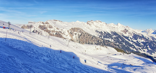 People on ski  and snowboards on winter sport resort in swiss al