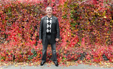 Осенний фон. Мужчина возле  листьев  винограда