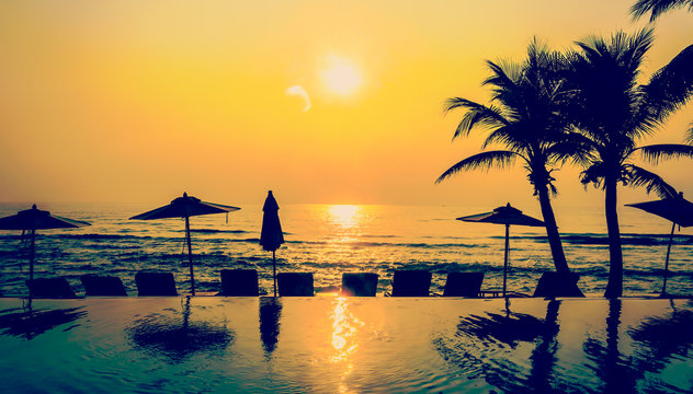 Fototapeta Sylwetka basen plaża i palmy zachód słońca
