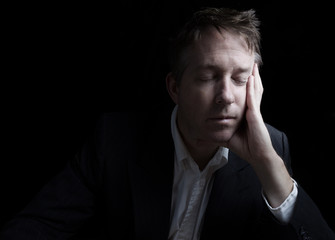 Unemployed depressed man resting his eyes