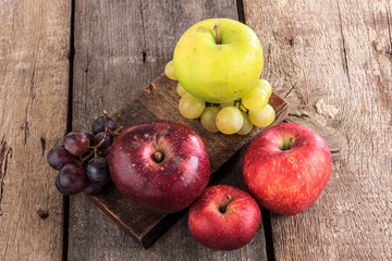 fresh organic fruits , apples and grapes on the wooden table
