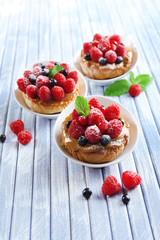 Sweet cakes with berries on table close-up