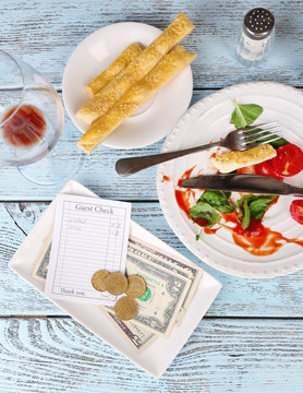 Check And Remnants Of Food On Table In Restaurant