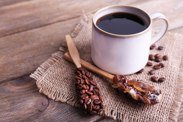 Mug of coffee on sackcloth on wooden background