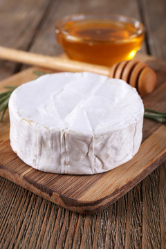Camembert cheese and honey in glass bowl