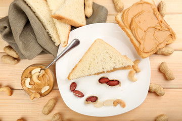 Bread slices with creamy peanut butter on wooden table