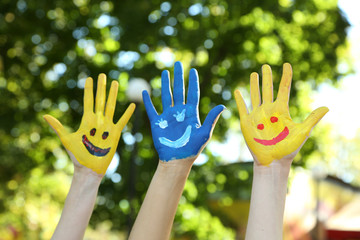 Smiling colorful hands on natural background