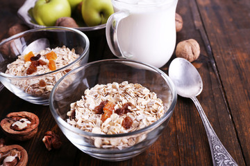 Oatmeal in bowls, yogurt, apples, dried apricots and walnuts