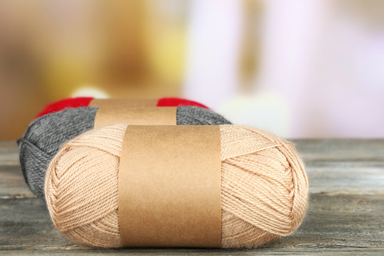 Knitting yarn on wooden table, on light background