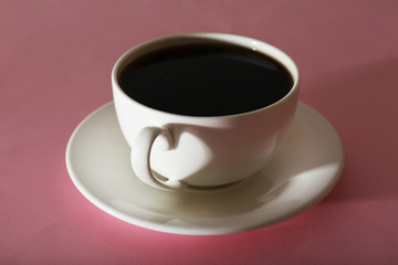 Cup of coffee on pink background