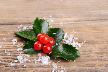 Leaves of mistletoe with berries on wooden background