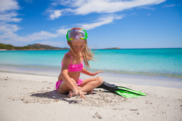 Little girl with flippers and goggles for ssnorkling on the