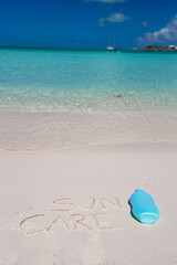 Suncare written on tropical white sand and suncream