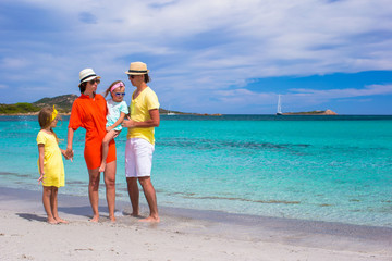 Happy family of four on beach vacation