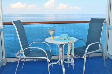 Cruise ship balcony chairs, table and tropical drink