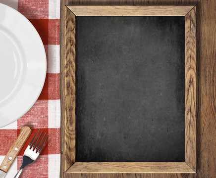 Menu blackboard top view on table with plate, knife and fork