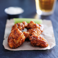 boneless barbecue chicken wings with beer on slate surface
