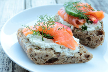 Plate with bread with salmon, white cheese and fennel