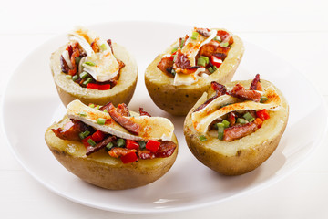 Baked potatoes stuffed with bacon, served with camembert