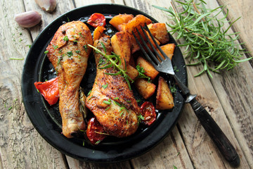 Roasted chicken legs with fried potatoes and fresh herbs
