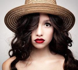Glamorous portrait of a brunette in a straw hat.