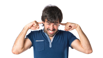 Fototapeta premium Man covering his ears over white background
