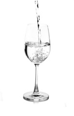 pouring water on a glass on white background