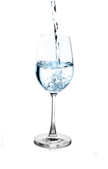 pouring water on a glass on white background