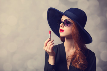 Style redhead women with sunglasses and lipstick.