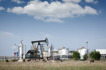 Fototapeta na wymiar oil pump jack and refinery on field