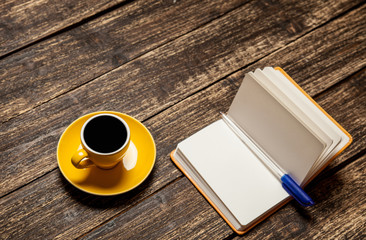 Coffee cup and notebook on a table.