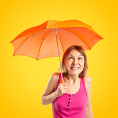 Girl holding an umbrella over yellow background