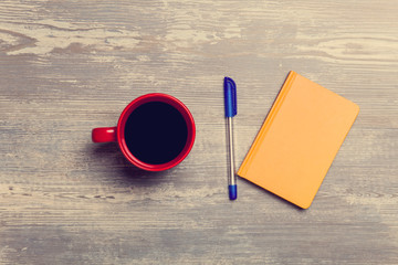 Coffee cup and notebook on a table.