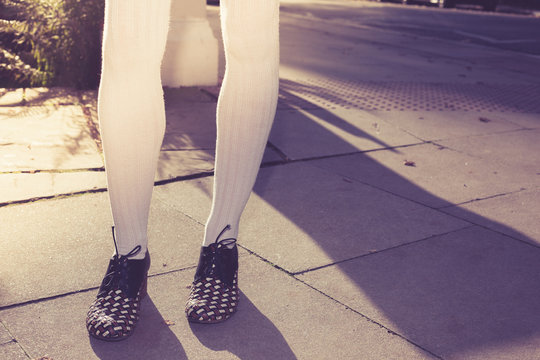 Legs of a woman standing in the street