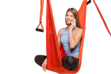 Young woman sitting in hammock for  aerial yoga