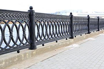 Cast iron grate fence on the embankment