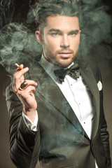 Close up picture of a business man blowing smoke