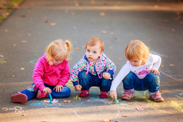 Obraz premium happy children draw with crayons on the pavement in the park