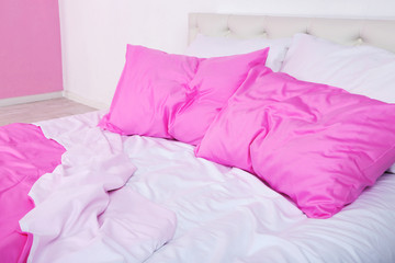 Crumpled pink linen on bed