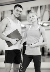 two smiling people with clipboard and measure tape