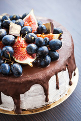 Chocolate cake with icing, decorated with fresh fruit