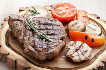 Portion of BBQ t-bone steak with  sauce  and grilled vegetables