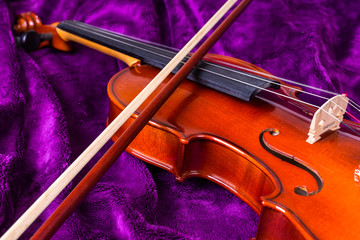 Fototapeta na wymiar Скрипка со смычком на фиолетовом фоне.