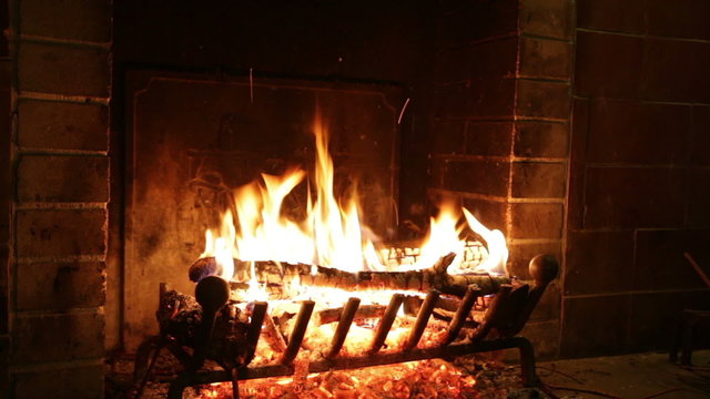 In an ancient stone fireplace fire burns