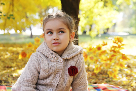Girl looking up under autumn tree