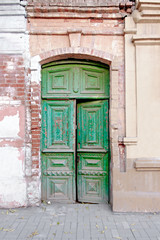 Old wooden door painted in green color in Russia
