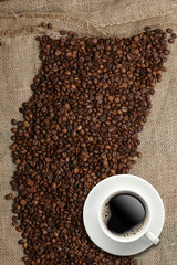 Coffee beans and Coffee cup on a jute background