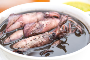 close up black squid boiled with seafood sauces