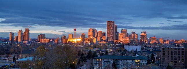 Calgary skyline in the early morning with rays from rising sun - obrazy, fototapety, plakaty